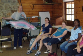 Jeff holding a large fish pillow to describe important identifying characteristics of fish.
